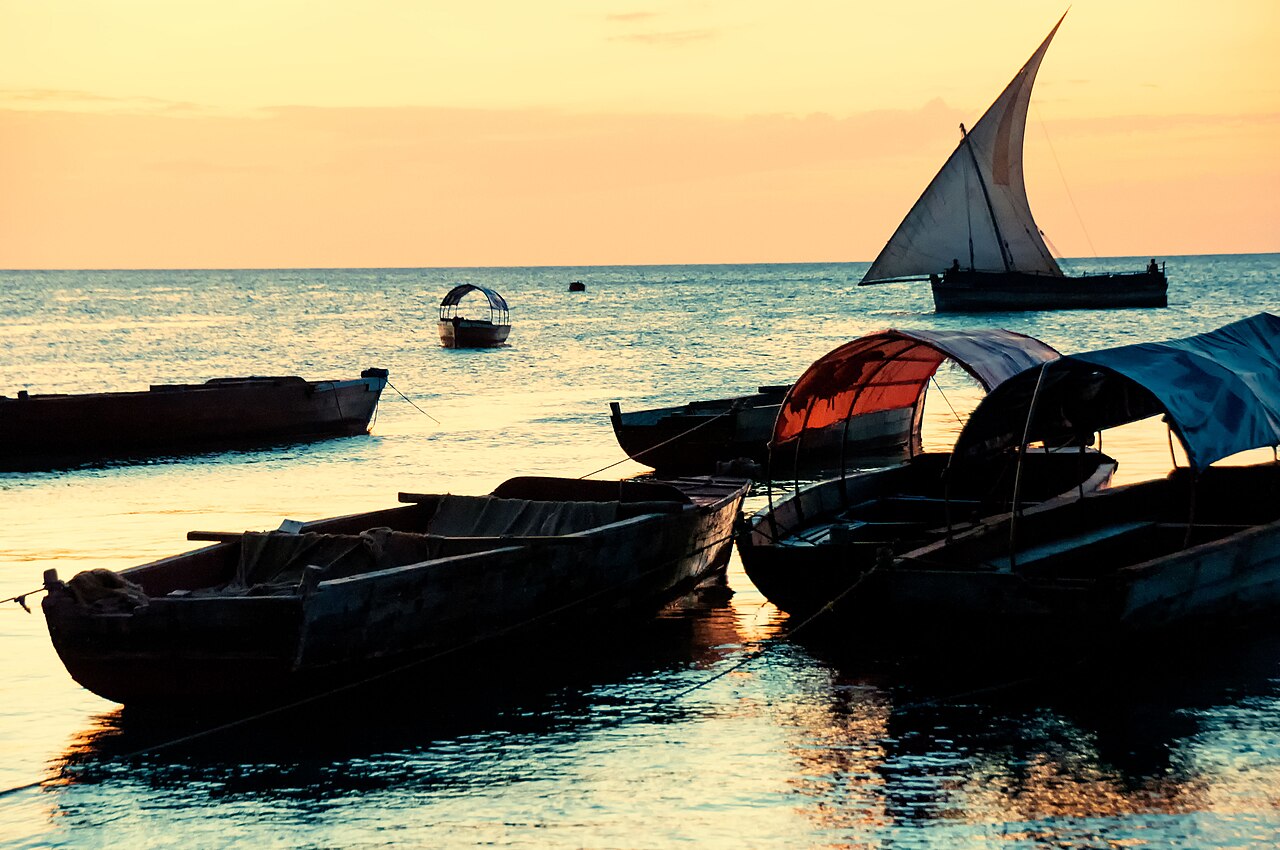 A traditional dhow with a lateen sail at sunset off the coast of Zanzibar